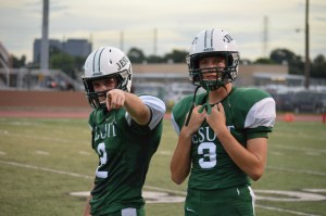 Blaise Bucey '15 and Perry Corrigan '15 get warmed up on the sideline but still have time for MAGIS. Photo: MAGIS
